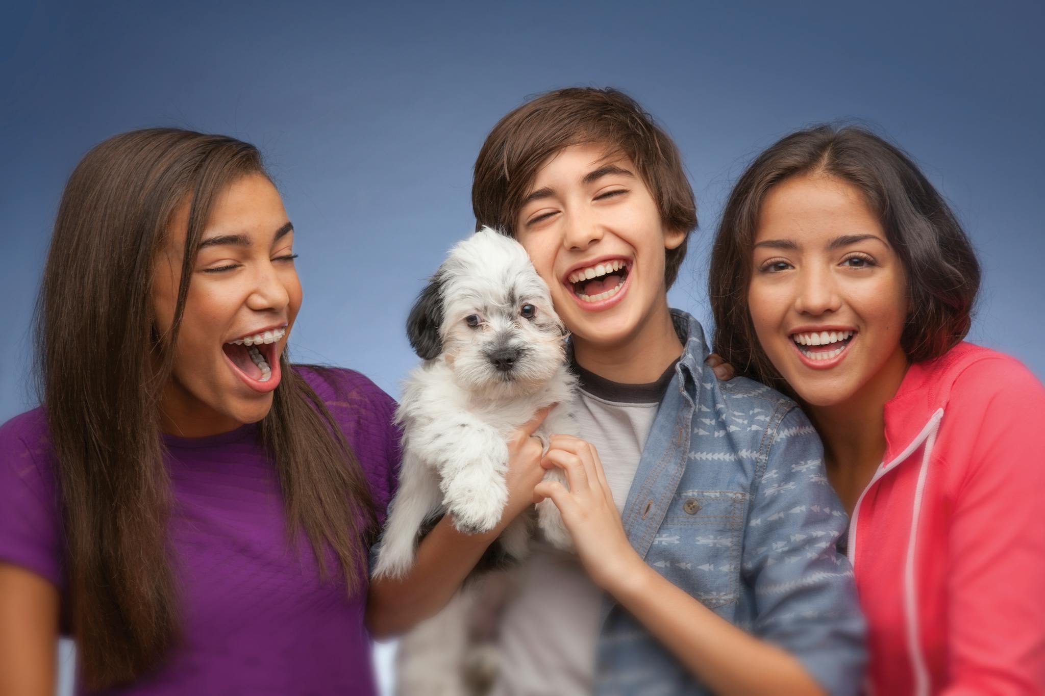 young people smiling with a dog
